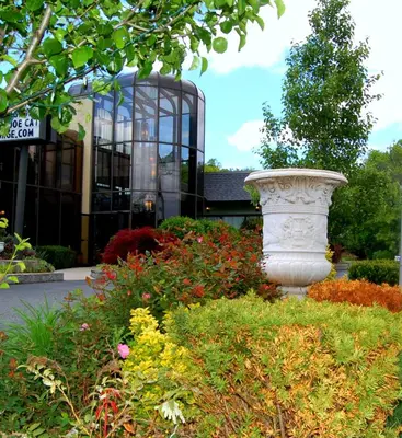a flower garden with a statue in front of a building at West Gate Inn Nyack in Nyack