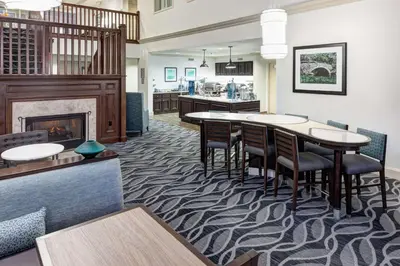a dining room with a fireplace and a table and chairs at Homewood Suites by Hilton Mahwah in Mahwah