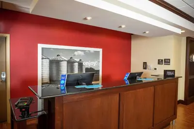 an office with a red wall and a desk with two computers at Hampton Inn Limerick in Limerick