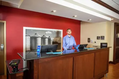 a man standing at a reception desk in an office at Hampton Inn Limerick in Limerick
