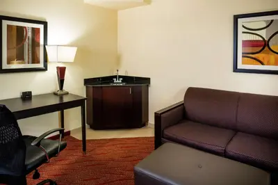 a living room with a couch and a desk and a chair at Hampton Inn Limerick in Limerick
