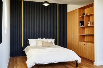 a bedroom with a bed with a black and yellow wall at Lokal Hotel Fishtown in Philadelphia