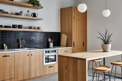a kitchen with wooden cabinets and a counter with stools at Lokal Hotel Fishtown in Philadelphia