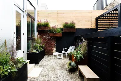 a patio with two chairs and a bench and plants at Lokal Hotel Fishtown in Philadelphia