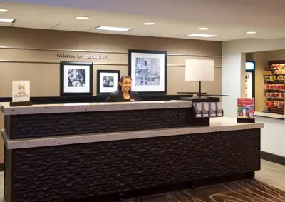 a woman standing behind a counter in a store at Hampton Inn Parsippany in Parsippany