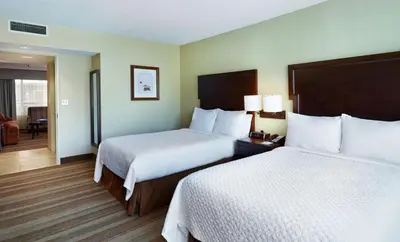 a hotel room with two beds with white sheets at Embassy Suites Parsippany in Parsippany