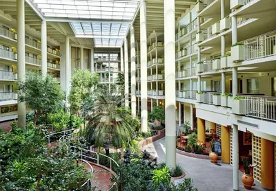 arium of an apartment building with plants and trees at Embassy Suites Parsippany in Parsippany