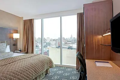 a hotel room with a bed and a large window at Wyndham Garden Chinatown in New York