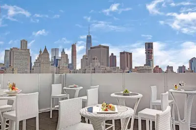 a rooftop patio with tables and chairs and a city skyline at Wyndham Garden Chinatown in New York