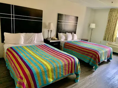 a hotel room with two beds with colorful blankets at Tappan Zee Hotel in West Nyack