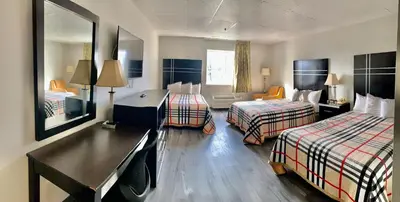 a hotel room with two beds and a desk at Tappan Zee Hotel in West Nyack
