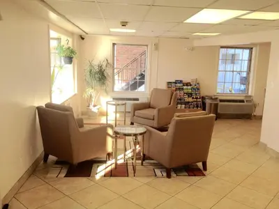 a waiting room with two chairs and a table at Tappan Zee Hotel in West Nyack