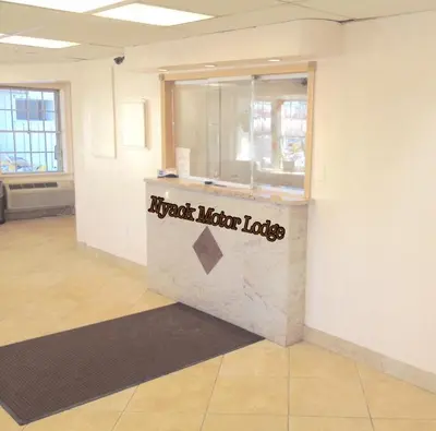 a restaurant counter with a sign on the wall at Tappan Zee Hotel in West Nyack