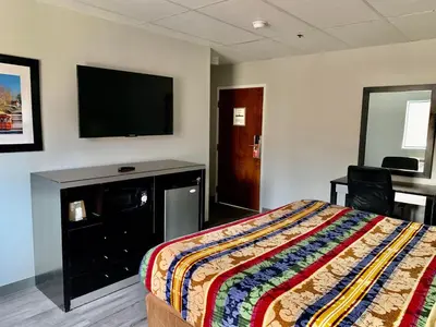 a bedroom with a bed and a flat screen tv at Tappan Zee Hotel in West Nyack