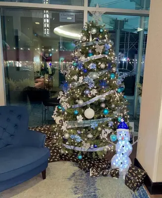 a christmas tree in a room with a blue couch at Holiday Inn Express - Times Square South by IHG in New York