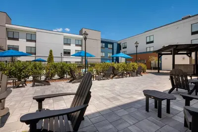 a patio with chairs and tables and blue umbrellas at Hampton Inn Princeton in Princeton