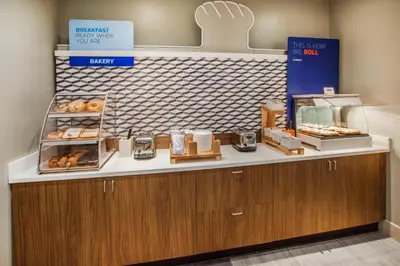 a bakery with a counter with donuts on it at Holiday Inn Express - Newark Airport - Elizabeth by IHG in Elizabeth