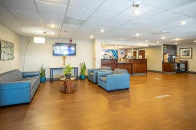 a lobby with blue couches and a flat screen tv at Holiday Inn Express - Newark Airport - Elizabeth by IHG in Elizabeth