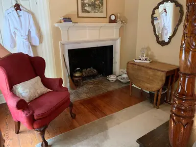 a living room with a chair and a fireplace at The Lily Inn - Burlington in Burlington