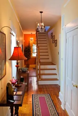 a hallway of a home with stairs and a lamp at The Lily Inn - Burlington in Burlington