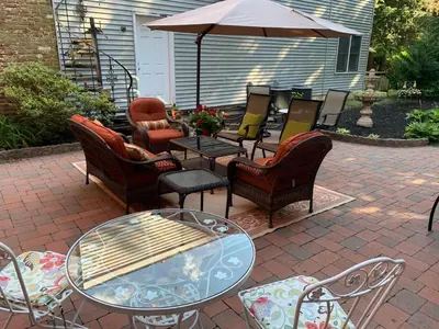 a patio with chairs and tables and an umbrella at The Lily Inn - Burlington in Burlington