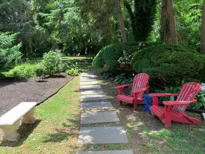 two red chairs and a bench in a park at The Lily Inn - Burlington in Burlington