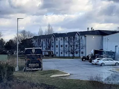 a large white building with cars parked in a parking lot at Microtel Inn & Suites by Wyndham West Chester in West Chester