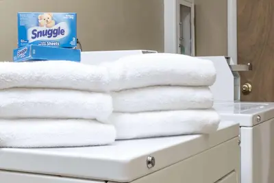 a pile of towels on a counter in a bathroom at Microtel Inn & Suites by Wyndham West Chester in West Chester