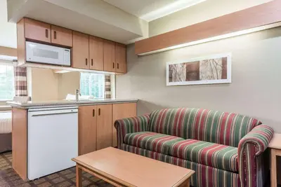 a living room with a couch and a kitchen at Microtel Inn & Suites by Wyndham West Chester in West Chester