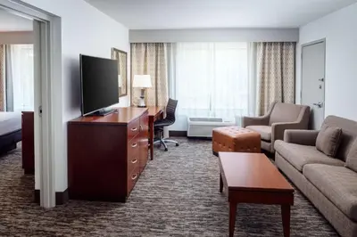 a hotel room with a television and a living room at DoubleTree by Hilton Princeton in Princeton