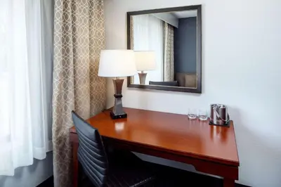 a desk in a hotel room with a lamp and a mirror at DoubleTree by Hilton Princeton in Princeton