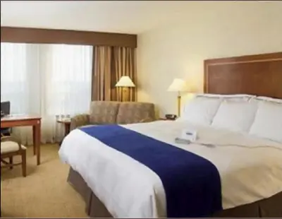 a hotel room with a large bed and a desk at Hotel Executive Suites in Carteret
