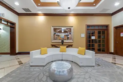 a living room with a white couch and yellow pillows at Hotel Executive Suites in Carteret