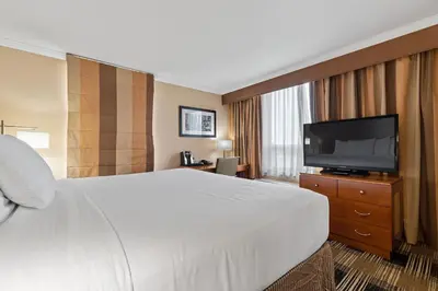 a hotel room with a bed and a flat screen tv at Hotel Executive Suites in Carteret