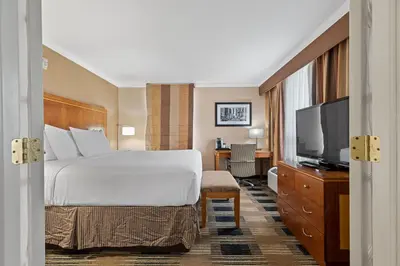 a hotel room with a bed and a flat screen tv at Hotel Executive Suites in Carteret