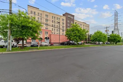an empty street in front of a large building at Hotel Executive Suites in Carteret