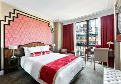 a bedroom with a large bed with a red headboard at Walker Hotel Greenwich Village in New York