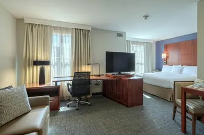 a hotel room with a bed and a desk with a television at Residence Inn by Marriott Woodbridge Edison/Raritan Center in Woodbridge