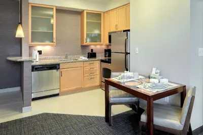 a small kitchen with a table and a refrigerator at Residence Inn by Marriott Woodbridge Edison/Raritan Center in Woodbridge
