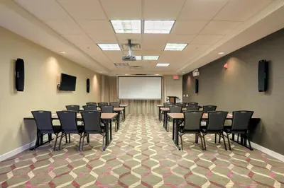 a conference room with tables and chairs and a whiteboard at Residence Inn by Marriott Woodbridge Edison/Raritan Center in Woodbridge