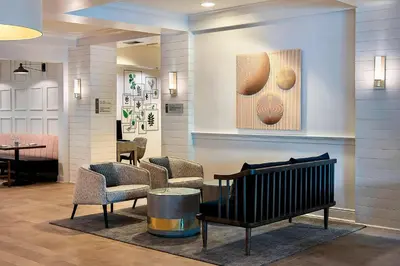 a waiting room with chairs and a bench and a table at Delta Hotels by Marriott Basking Ridge in Basking Ridge