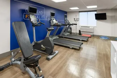 a gym with cardio machines and a blue wall at Holiday Inn Express Philadelphia Penn's Landing by IHG in Philadelphia