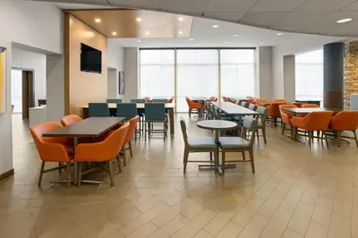 a dining area with tables and chairs in a cafeteria at Holiday Inn Express Philadelphia Penn's Landing by IHG in Philadelphia