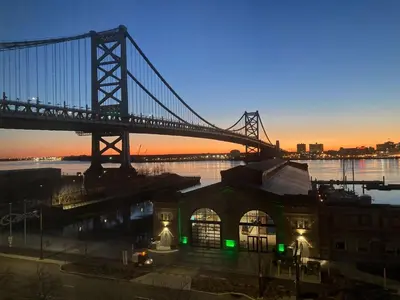 a bridge over the water with a building with green lights at Holiday Inn Express Philadelphia Penn's Landing by IHG in Philadelphia