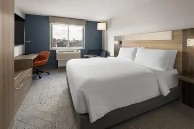 a bedroom with a white bed and a desk and a window at Holiday Inn Express Philadelphia Penn's Landing by IHG in Philadelphia