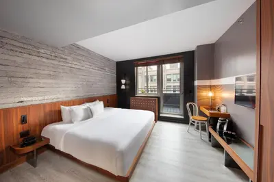 a hotel room with a large bed and a desk at Hotel Henri NY in New York