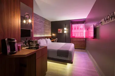 a hotel room with a large bed and a desk at Hotel Henri NY in New York