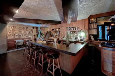 a bar with bar stools in a room at Hotel Henri NY in New York