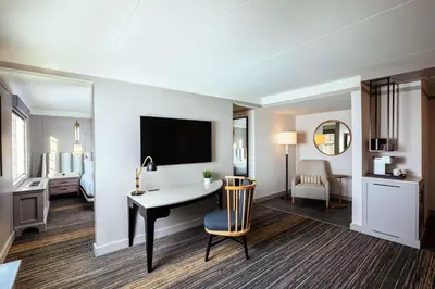 a hotel room with a desk and a tv at Somerset Hills Hotel, Tapestry Collection by Hilton in Basking Ridge