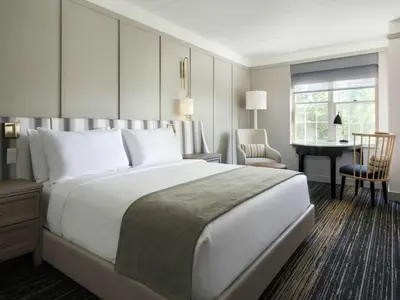 a hotel room with a large white bed and a desk at Somerset Hills Hotel, Tapestry Collection by Hilton in Basking Ridge